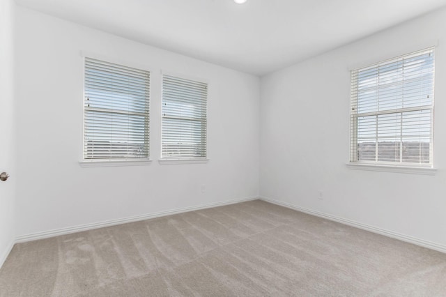 carpeted spare room featuring baseboards