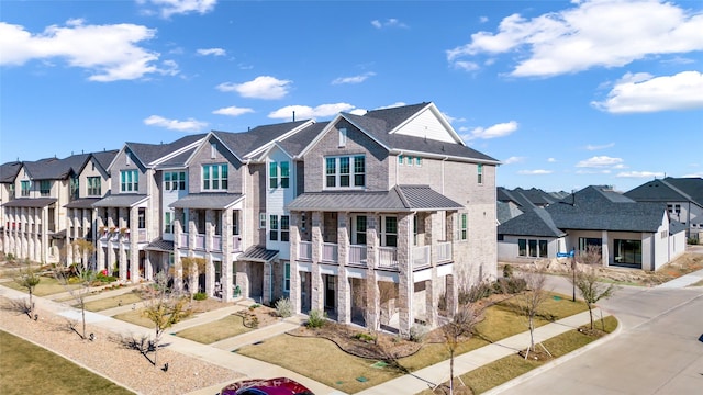 view of front of home featuring brick siding, a residential view, and stone siding