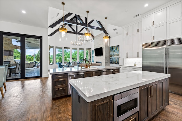 kitchen featuring visible vents, a spacious island, a chandelier, built in appliances, and open floor plan