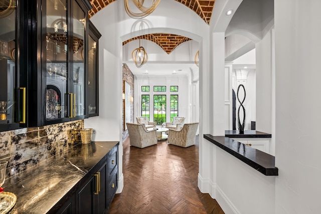 bar featuring brick ceiling, arched walkways, vaulted ceiling, a bar, and recessed lighting