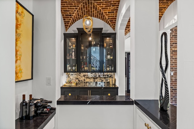 bar featuring indoor wet bar, brick ceiling, and lofted ceiling