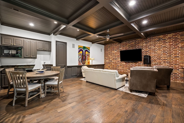 living room with beamed ceiling, wood finished floors, and a wainscoted wall