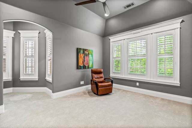 living area with carpet flooring, a ceiling fan, baseboards, vaulted ceiling, and visible vents