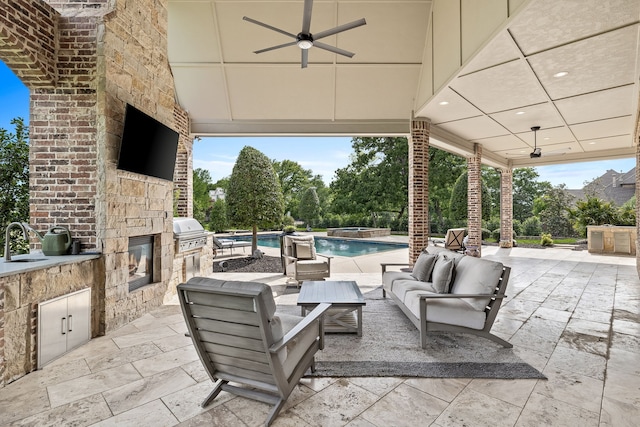 view of patio / terrace with area for grilling, an outdoor living space, a ceiling fan, an outdoor pool, and an outdoor kitchen