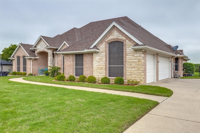 ranch-style home featuring driveway, a front yard, brick siding, a shingled roof, and stone siding