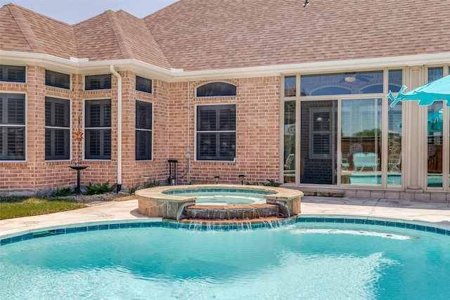 pool featuring a patio and an in ground hot tub
