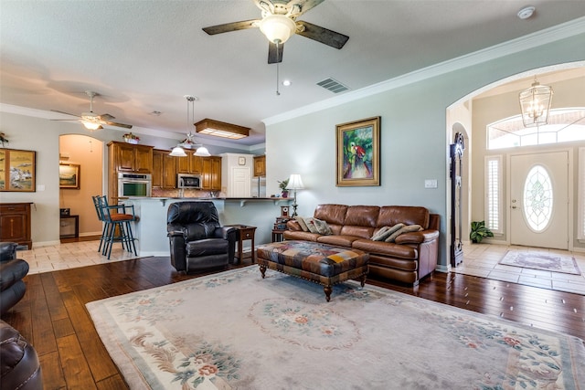 living room with a ceiling fan, visible vents, and light wood finished floors