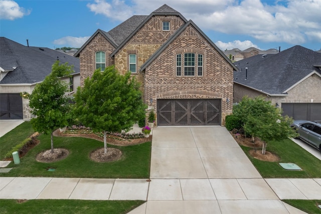 traditional-style home with concrete driveway, brick siding, an attached garage, and a front lawn
