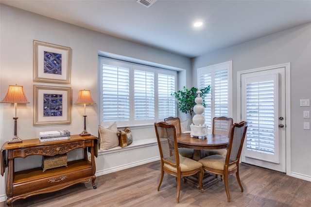 dining area with baseboards and wood finished floors