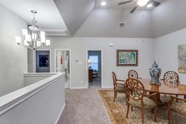 dining space featuring visible vents, baseboards, high vaulted ceiling, ceiling fan with notable chandelier, and light carpet