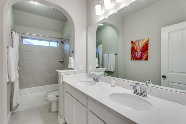 bathroom with double vanity, a sink, tile patterned floors, and toilet
