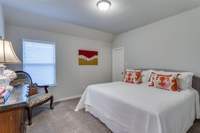 carpeted bedroom with baseboards and vaulted ceiling