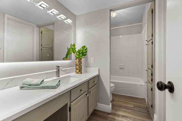 bathroom with bathtub / shower combination, vanity, toilet, baseboards, and wood finished floors