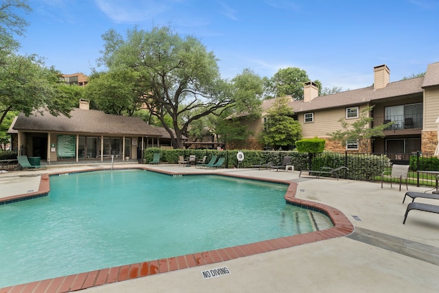 pool with fence and a patio area