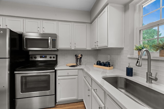 kitchen with a sink, appliances with stainless steel finishes, and white cabinets