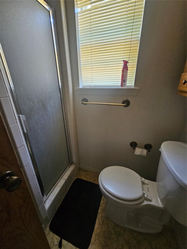 full bath with baseboards, a shower stall, and toilet
