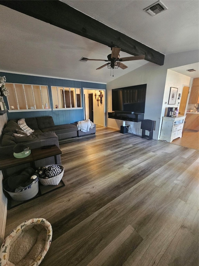 living room with a ceiling fan, visible vents, vaulted ceiling with beams, and wood finished floors