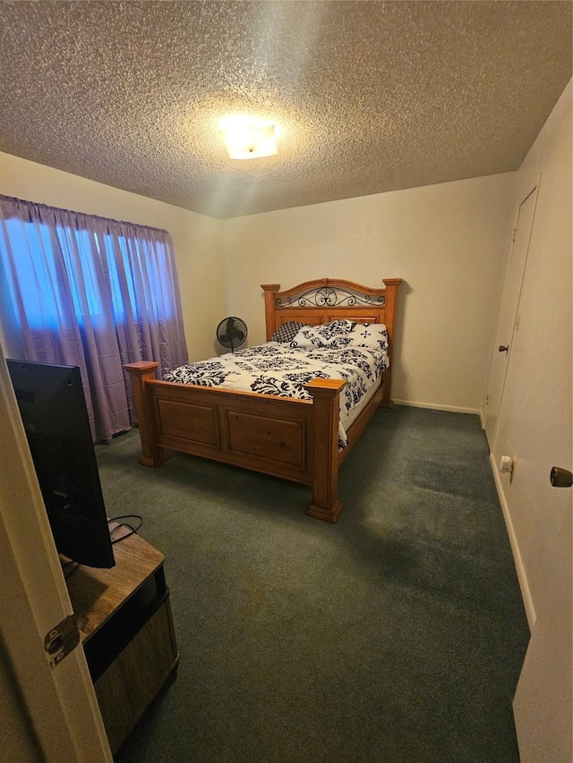 bedroom with a textured ceiling and dark colored carpet