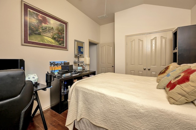 bedroom featuring a closet, visible vents, attic access, dark wood-type flooring, and vaulted ceiling