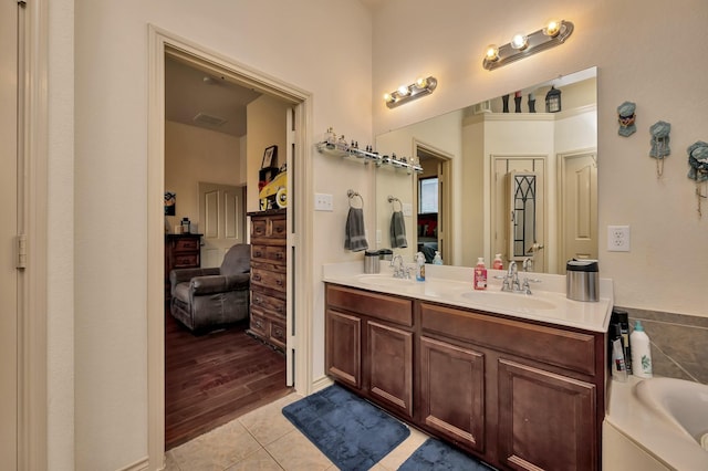 ensuite bathroom with double vanity, tile patterned flooring, a sink, and ensuite bathroom