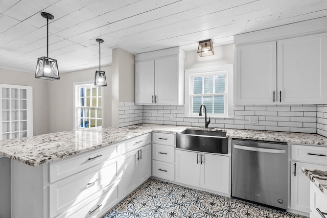 kitchen featuring a peninsula, a wealth of natural light, a sink, and dishwasher