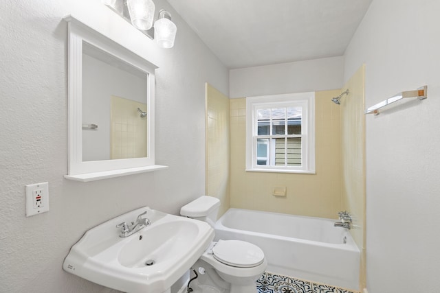 bathroom with a sink, shower / bathing tub combination, and toilet