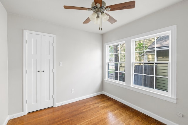empty room featuring baseboards, ceiling fan, and wood finished floors