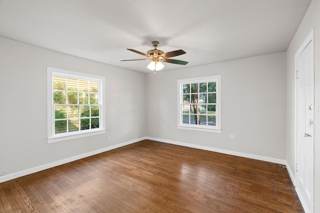 unfurnished bedroom featuring baseboards, multiple windows, and wood finished floors
