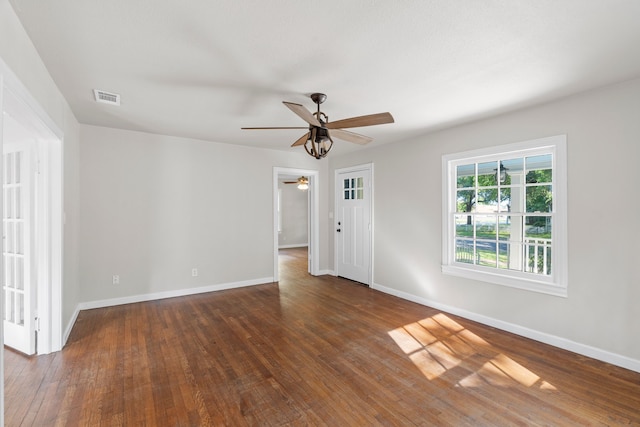 unfurnished room with baseboards, wood-type flooring, a ceiling fan, and visible vents