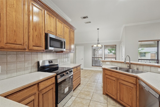 kitchen with decorative backsplash, brown cabinetry, crown molding, appliances with stainless steel finishes, and a sink