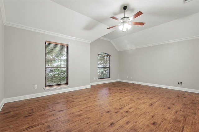 spare room featuring ornamental molding, lofted ceiling, wood finished floors, baseboards, and ceiling fan