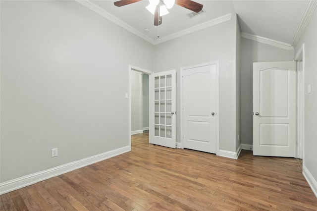 unfurnished bedroom with crown molding, wood finished floors, and visible vents