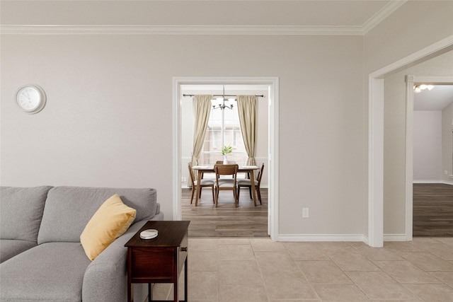living room featuring an inviting chandelier, ornamental molding, baseboards, and light tile patterned flooring