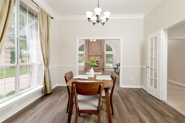 dining room featuring crown molding, baseboards, an inviting chandelier, and wood finished floors