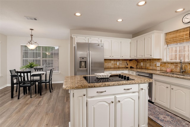 kitchen featuring white cabinets, appliances with stainless steel finishes, a sink, light wood-style flooring, and visible vents