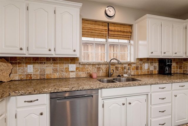 kitchen with stainless steel dishwasher, white cabinetry, decorative backsplash, and a sink
