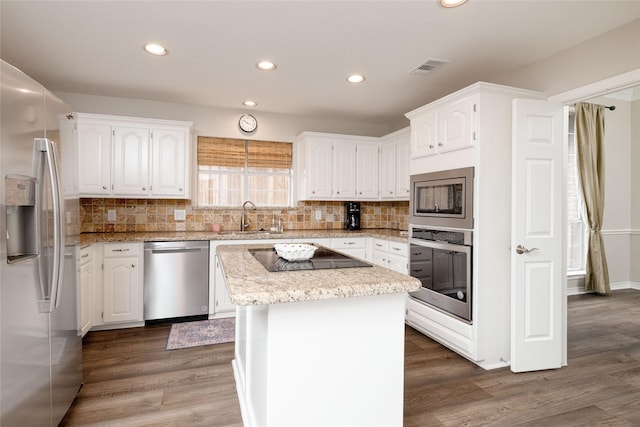 kitchen with a sink, stainless steel appliances, recessed lighting, and white cabinetry