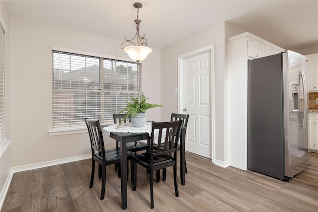 dining space with baseboards and light wood finished floors