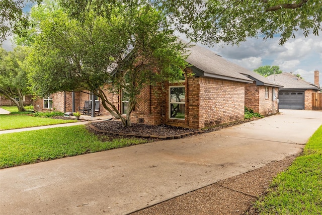 view of property exterior featuring a lawn, a garage, brick siding, concrete driveway, and a shingled roof