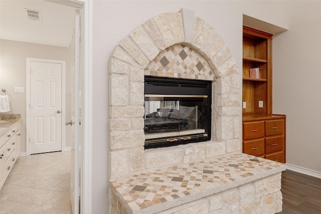 room details featuring baseboards, visible vents, and a stone fireplace