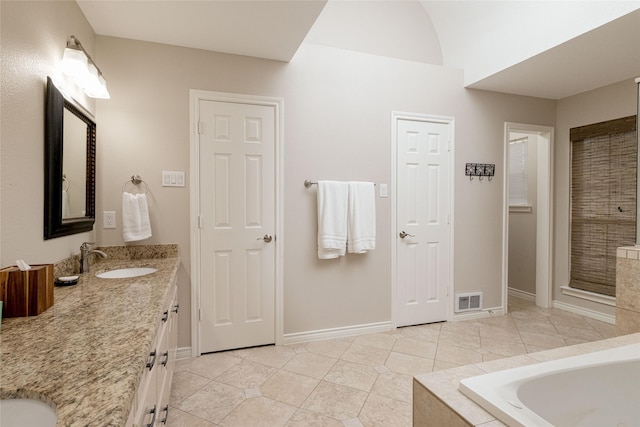 bathroom featuring baseboards, visible vents, a sink, and a bath
