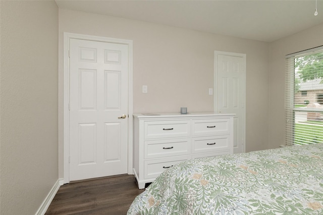 bedroom with dark wood-type flooring and baseboards
