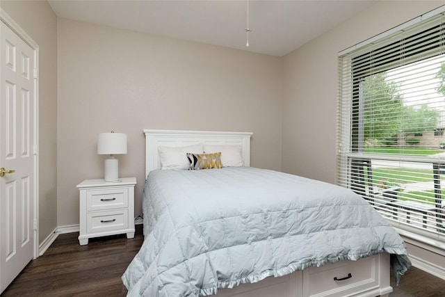 bedroom with baseboards and dark wood-type flooring