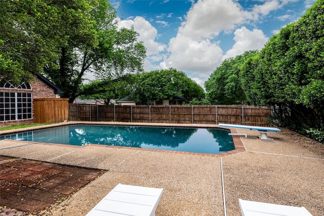 view of swimming pool with a fenced in pool, a fenced backyard, a patio area, and a diving board