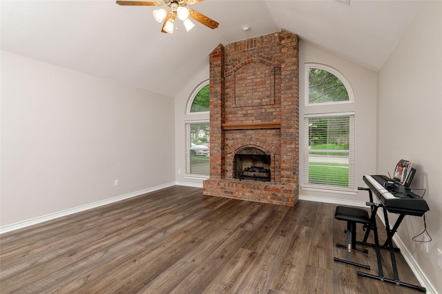 living area featuring a fireplace, high vaulted ceiling, a ceiling fan, baseboards, and wood finished floors