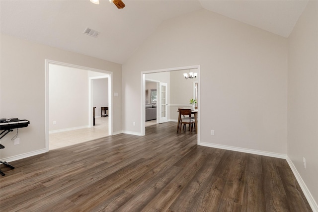unfurnished living room featuring visible vents, wood finished floors, high vaulted ceiling, baseboards, and ceiling fan with notable chandelier