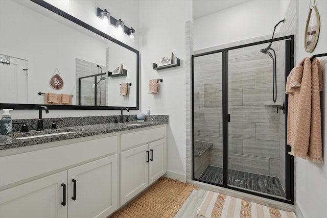 full bath with double vanity, tile patterned floors, a sink, and a stall shower