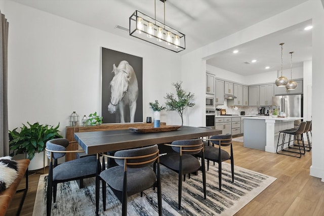 dining room featuring recessed lighting, an inviting chandelier, and light wood finished floors