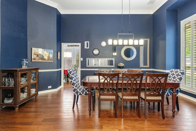 dining room featuring baseboards, ornamental molding, and hardwood / wood-style floors