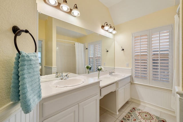 bathroom with tile patterned flooring, vanity, a wainscoted wall, curtained shower, and vaulted ceiling